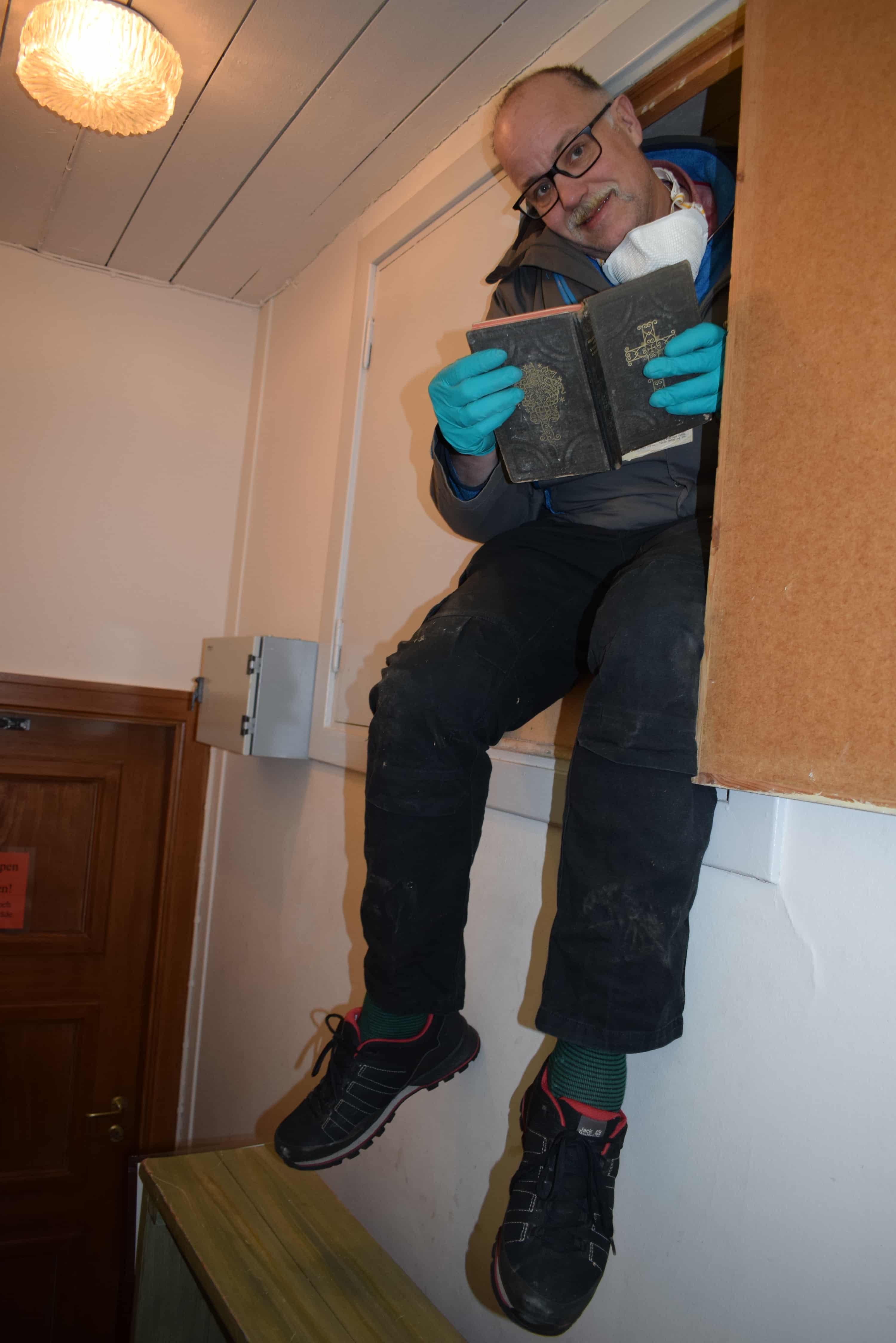 Otfried sitter i en luke høyt oppe på veggen