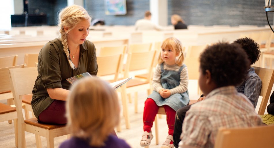 En kateket underviser en liten gruppe barn i en kirke