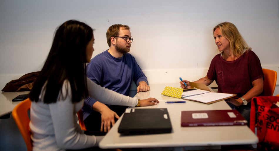 Veileder og praksisstudenter rundt et bord.