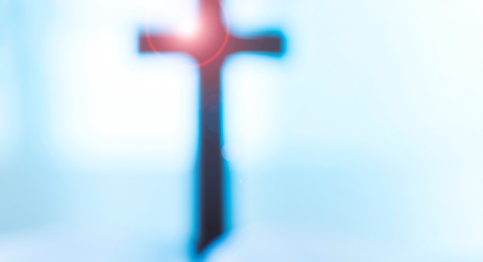 Oppslått Bibel foran vindu med glassmaleri