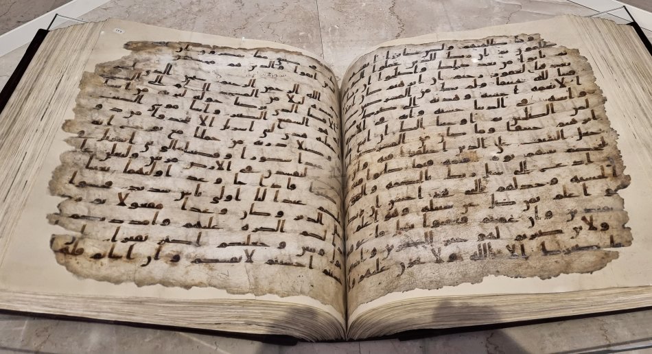 An open book with handwritten Arabic text visible