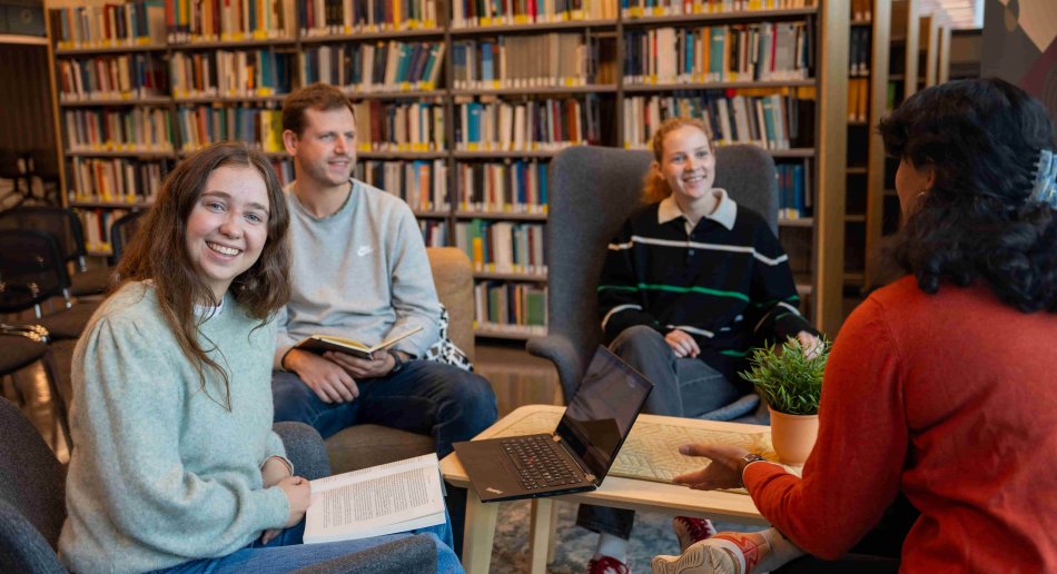 En gruppe studenter sitter på biblioteket på MF og har det hyggelig.