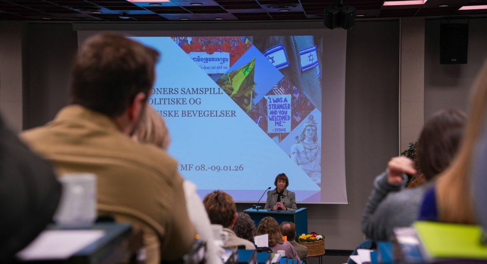 En dame snakker foran et fullsatt auditorium på januarkurset til MF