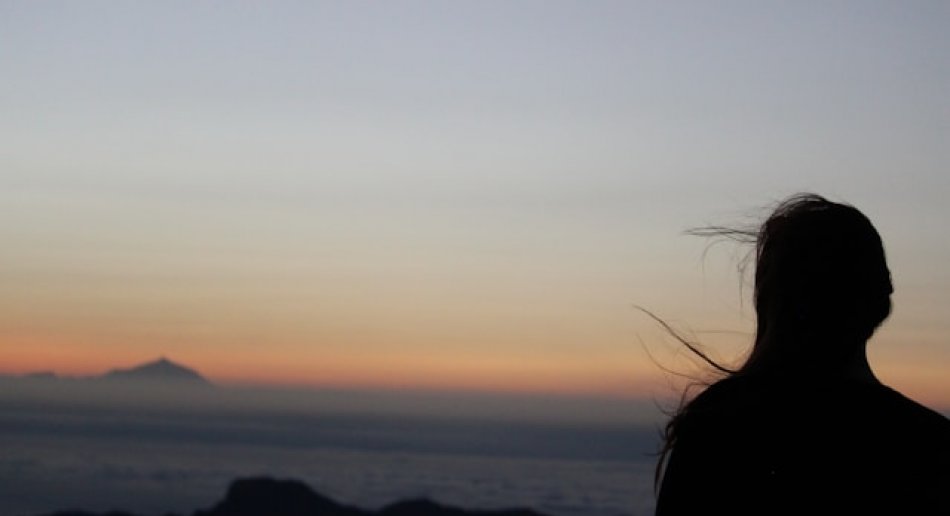 Silouette av person som ser ut mot havet