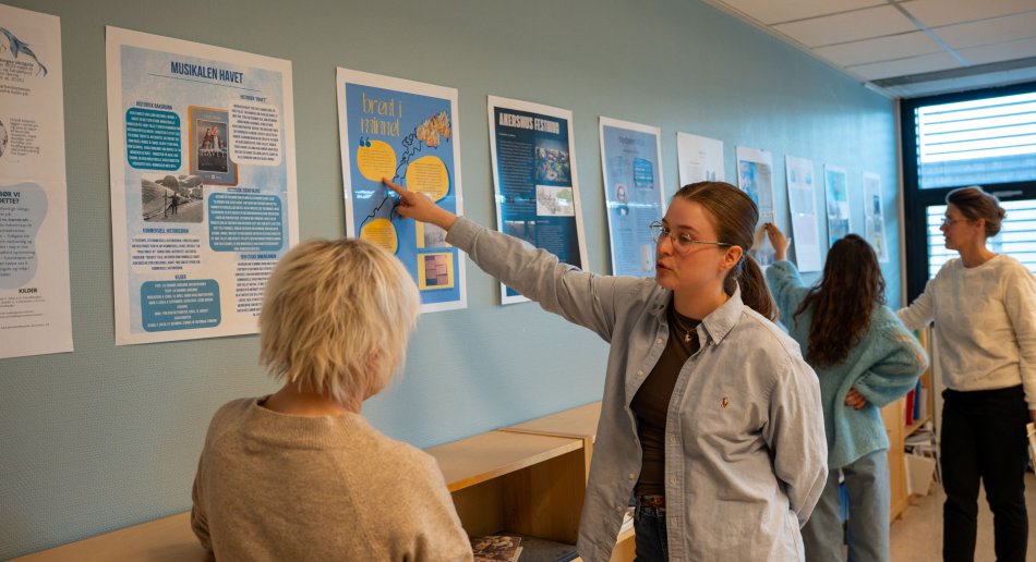 Studenter viser fram plakater 