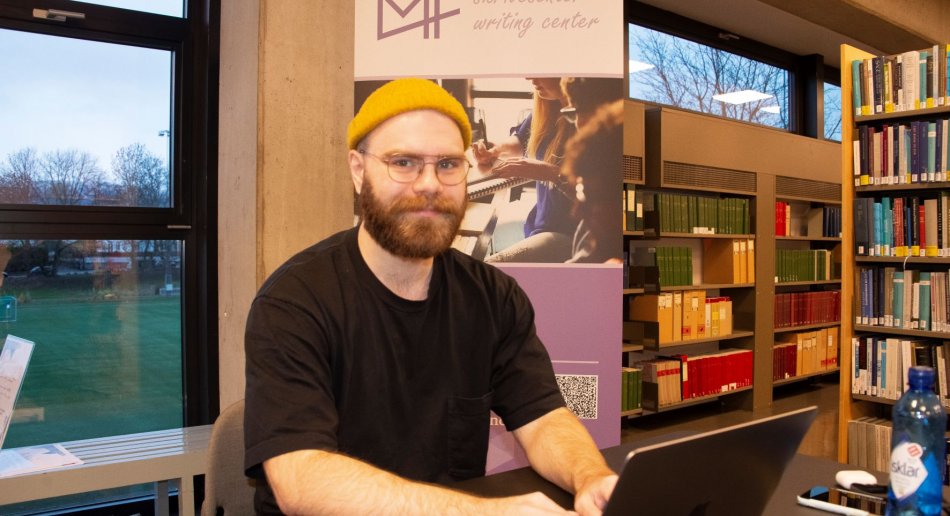Mannlig student med PC i et bibliotek