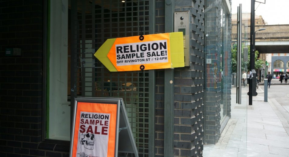 Oransje skilt som viser vei til "religion sample sale"