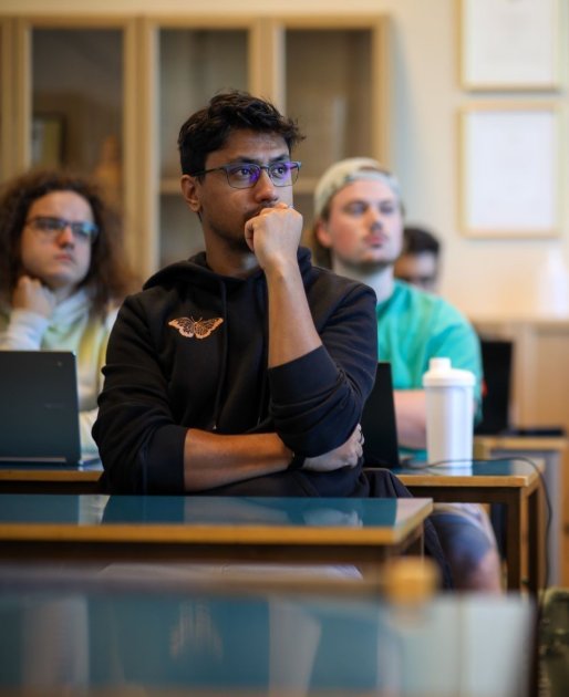 Male student sitting at a desk in one of MFs classrooms