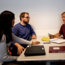 Veileder og praksisstudenter rundt et bord.