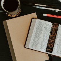 Åpen bibel med skrivesaker og kaffe